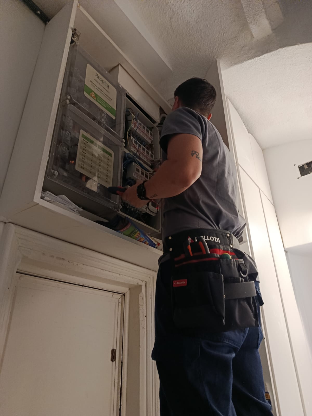 Técnico BORASO revisando cuadro eléctrico con cinturón de herramientas